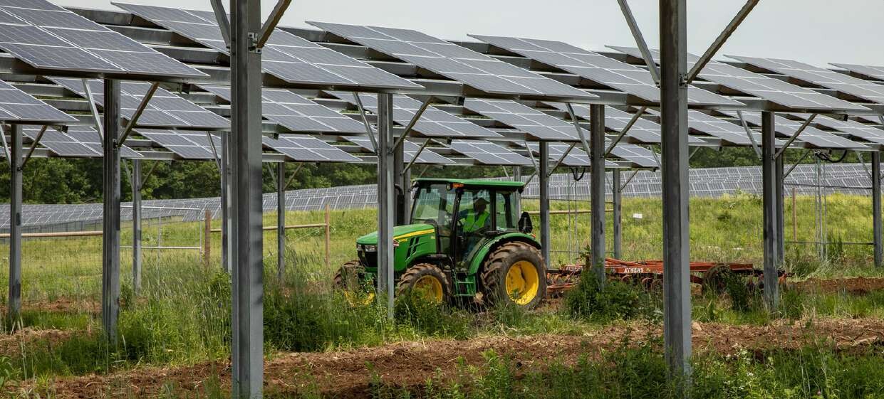 Agrivoltaic solar array with agricultural machinery operating beneath it